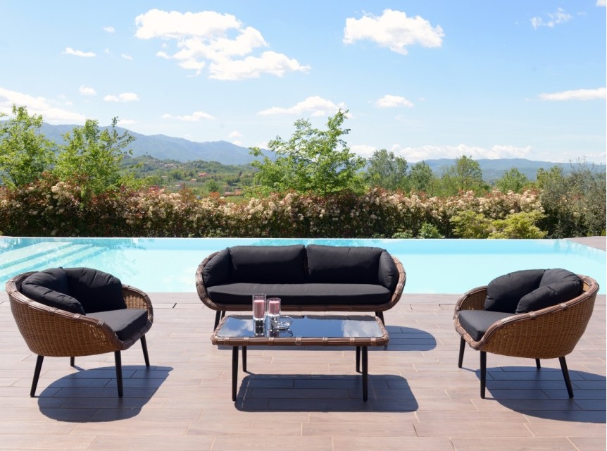 Il contrasto tra l'intreccio naturale e la cuscineria nera crea un look deciso e moderno, perfetto per ogni esterno.