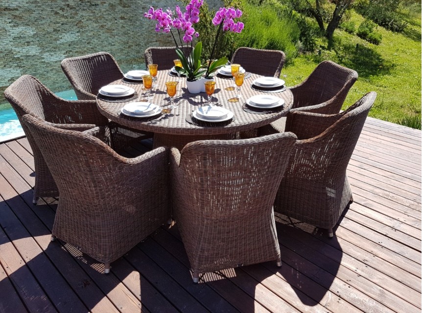 Tavolo tondo per esterno con otto poltrone intrecciate a mano