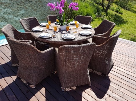 Tavolo tondo per esterno con otto poltrone intrecciate a mano